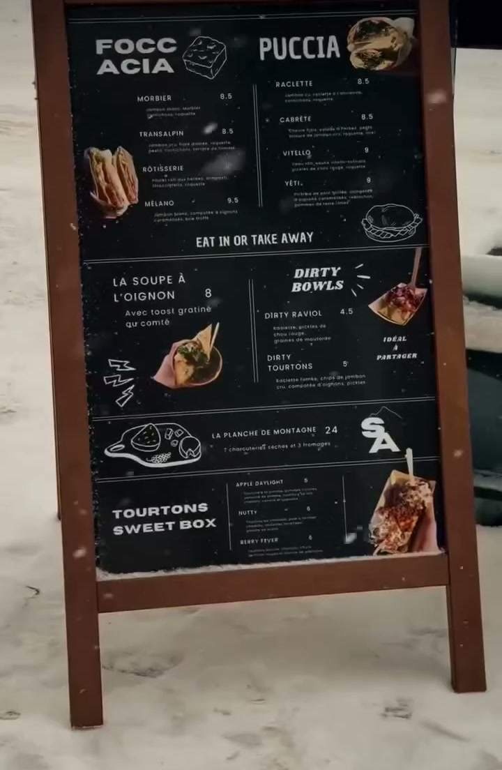Le tableau de la carte de Saveur Alpine, à Montgenèvre, posé dans la neige.